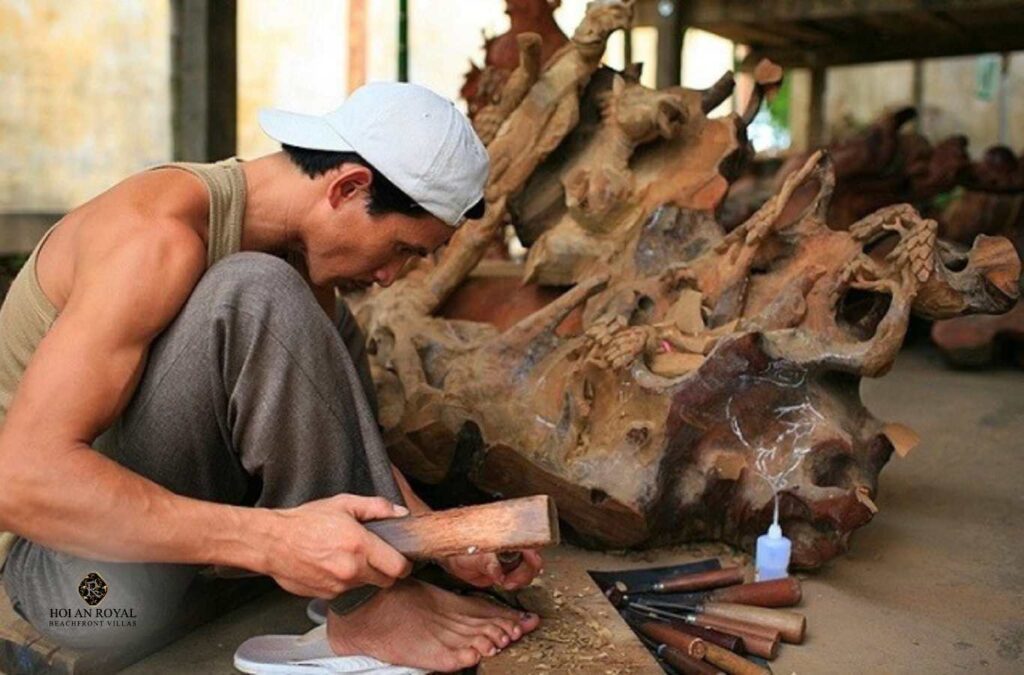 An artisan in Kim Bong Carpentry Village carefully carves every detail into wood with skillful hands